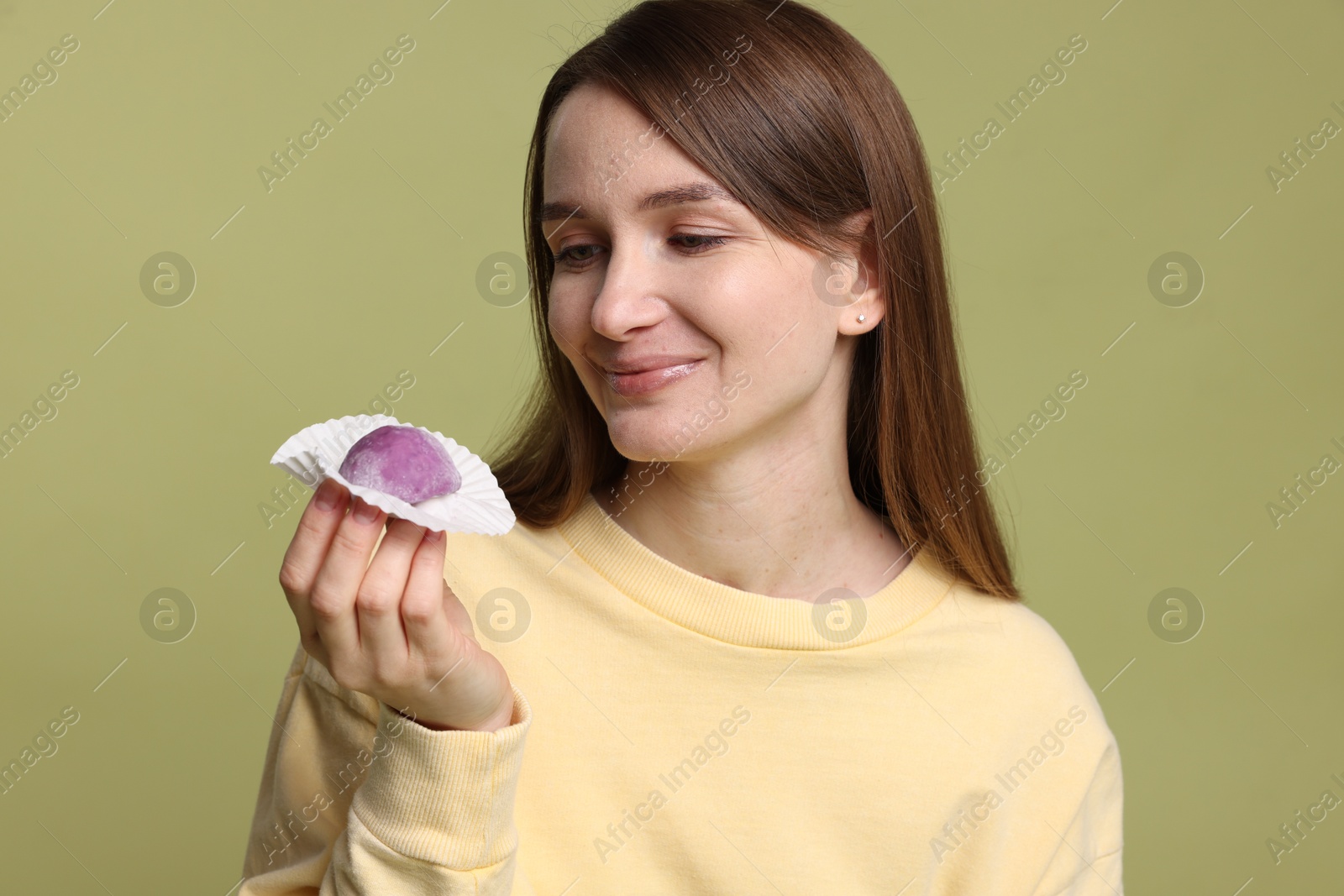 Photo of Woman with tasty mochi on olive background