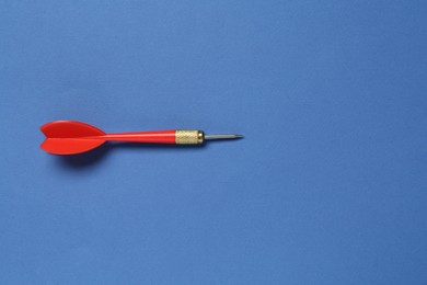 Photo of One red arrow on blue background, top view. Space for text