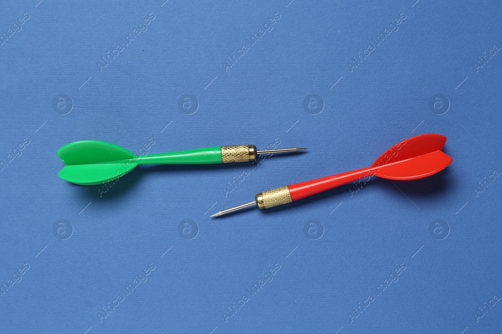 Photo of Colorful dart arrows on blue background, flat lay