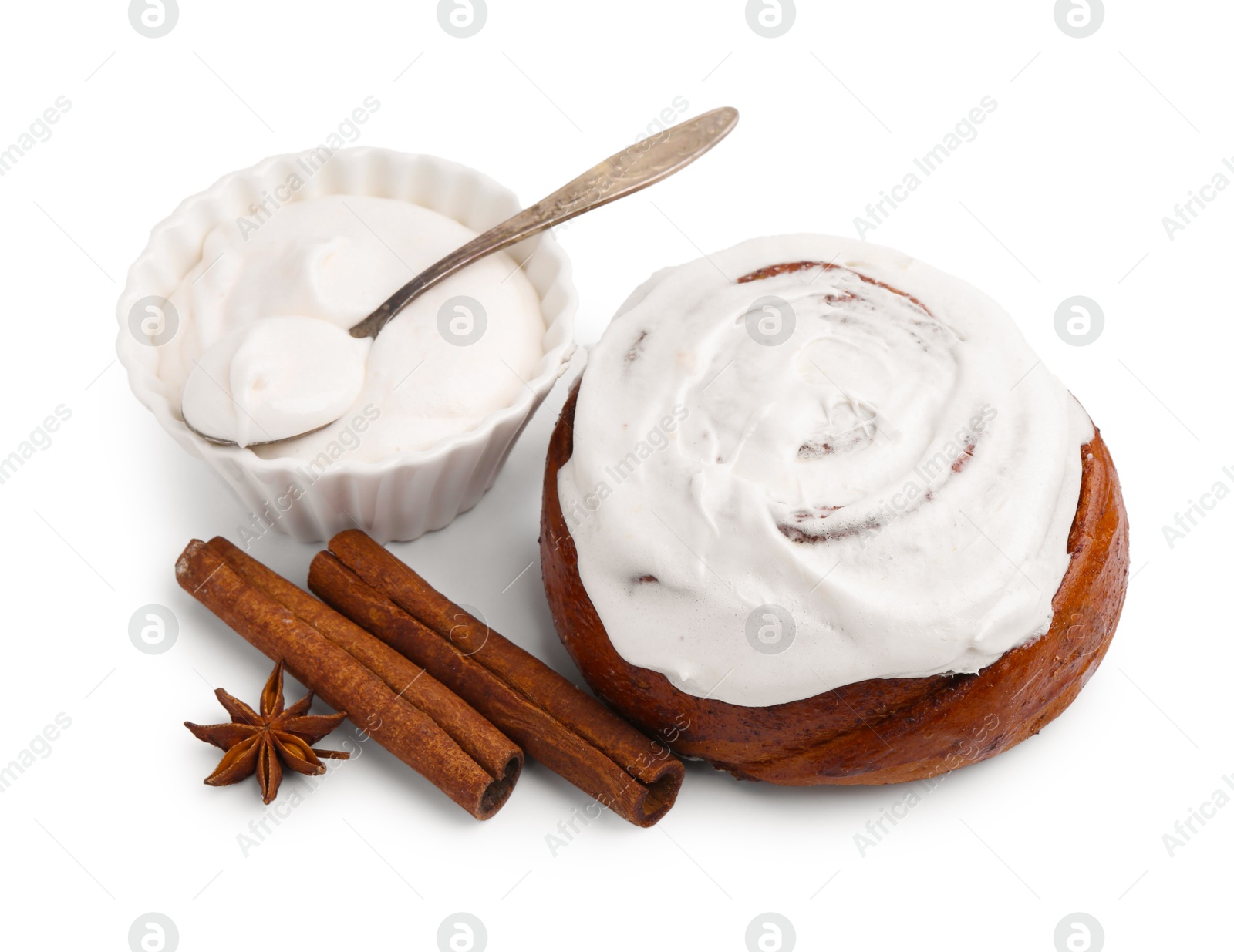 Photo of Tasty cinnamon roll with cream and spices isolated on white