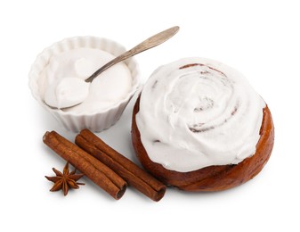 Photo of Tasty cinnamon roll with cream and spices isolated on white