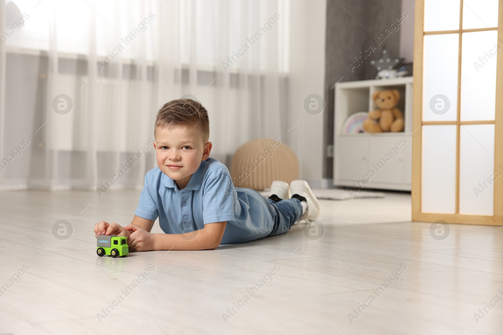 Photo of Little boy playing with toy car at home