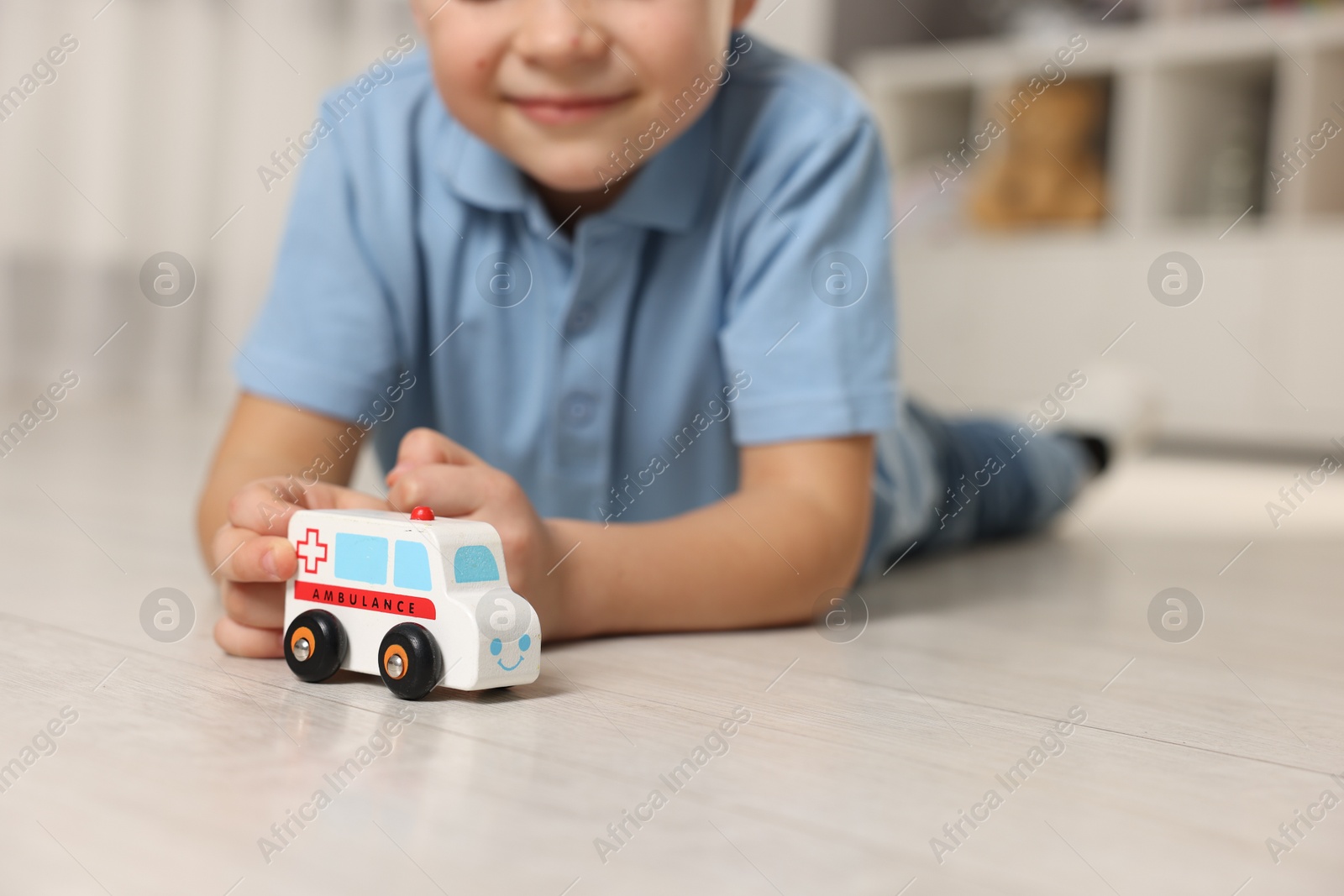 Photo of Little boy playing with toy car at home, closeup