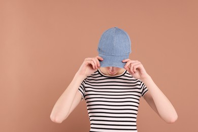 Photo of Woman in stylish baseball cap on beige background. Mockup for design