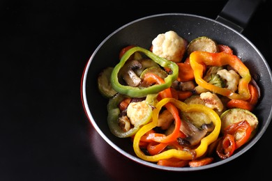 Photo of Frying pan with vegetables and mushrooms on stove, closeup