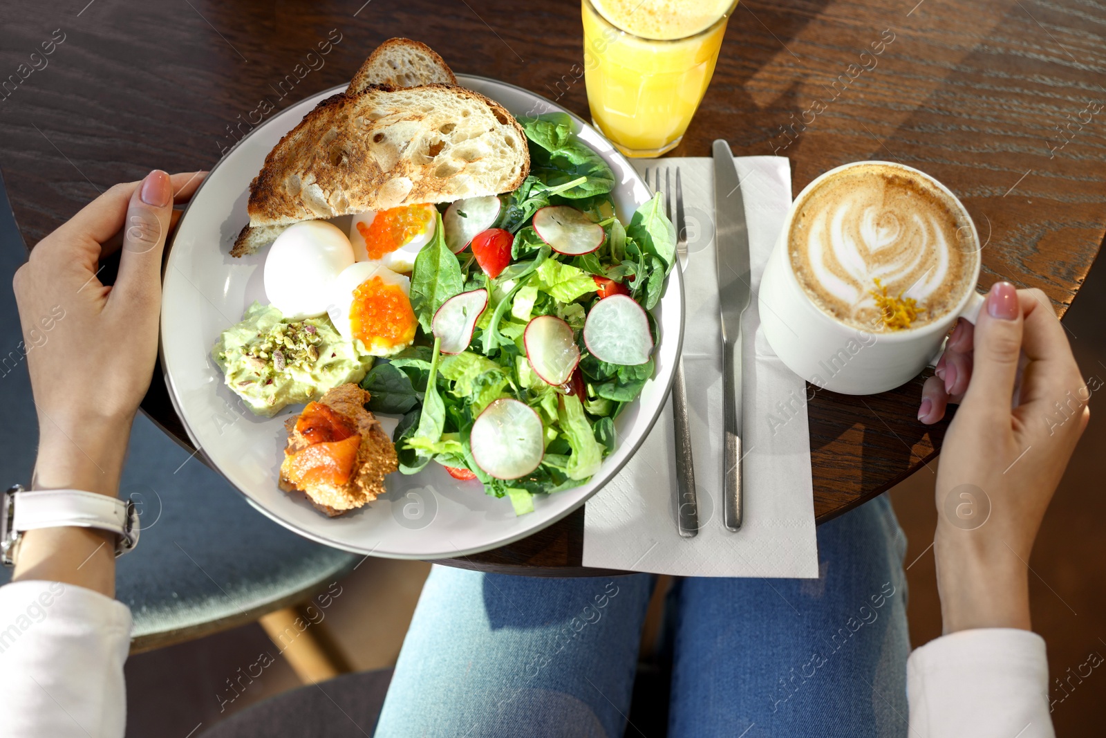 Photo of Woman having tasty breakfast in cafe, top view