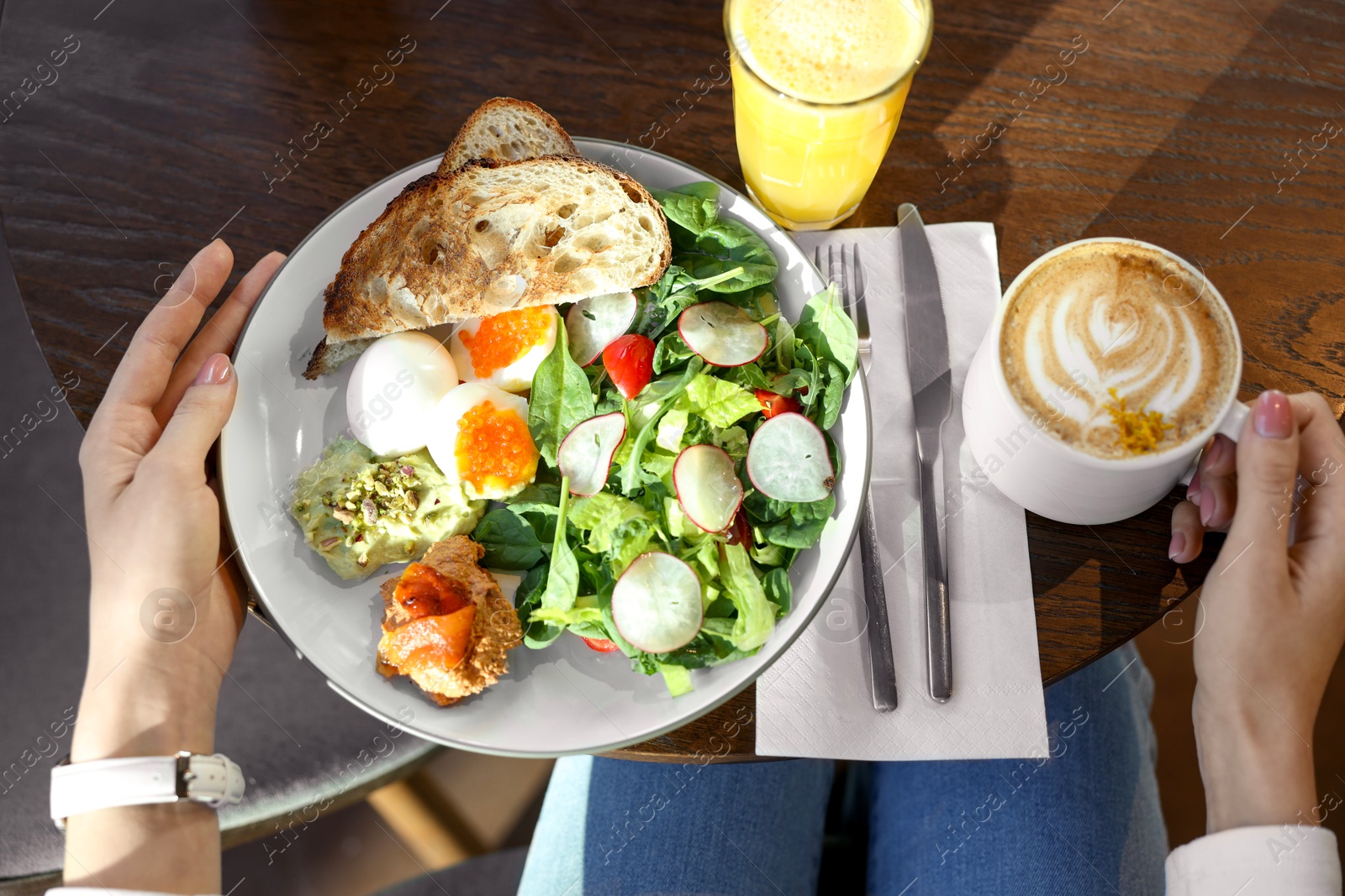 Photo of Woman having tasty breakfast in cafe, top view