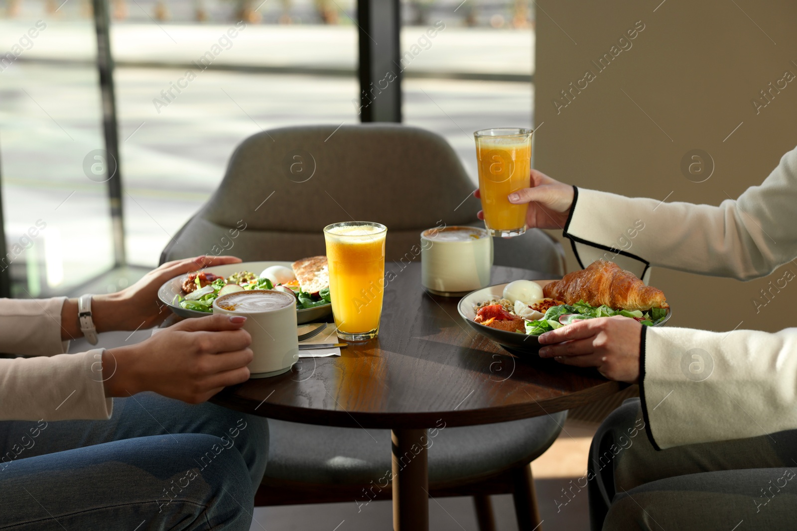 Photo of Women having tasty breakfast in cafe, closeup