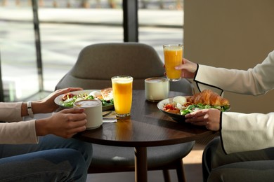 Photo of Women having tasty breakfast in cafe, closeup