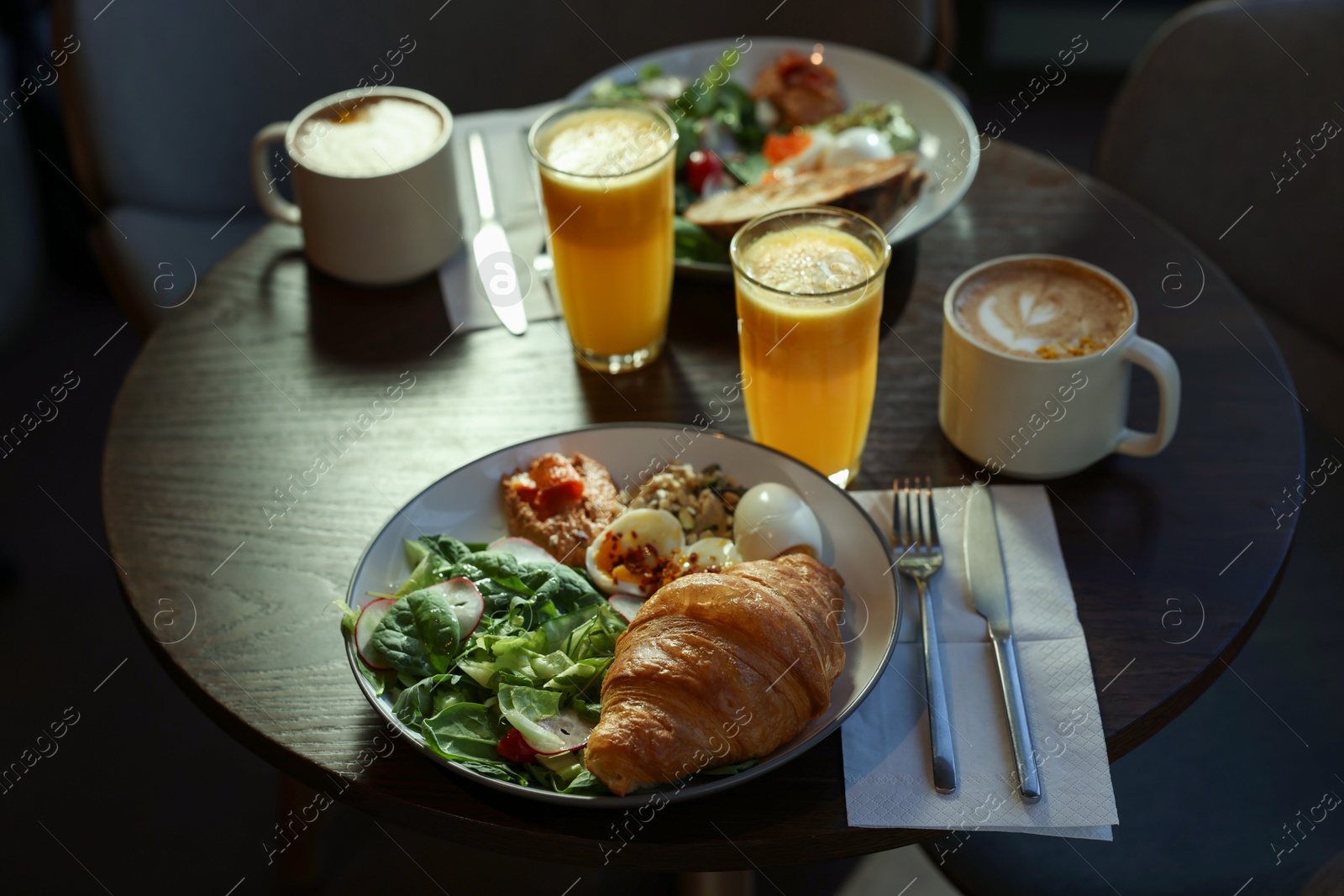 Photo of Tasty breakfast. Different meals and drinks served on wooden table in cafe, closeup