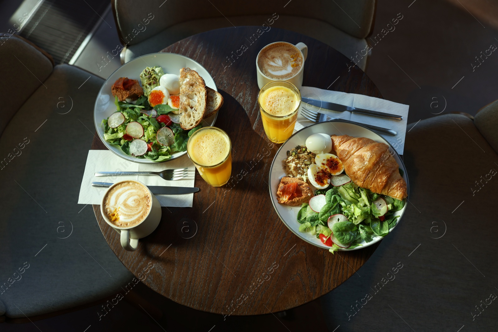 Photo of Tasty breakfast. Different meals and drinks served on wooden table in cafe, above view