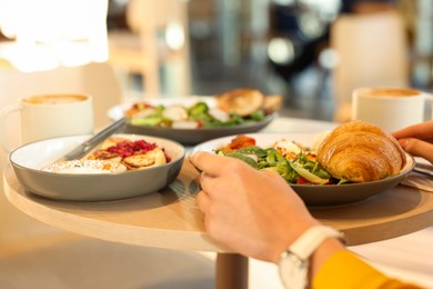 Photo of Woman having tasty breakfast in cafe, closeup