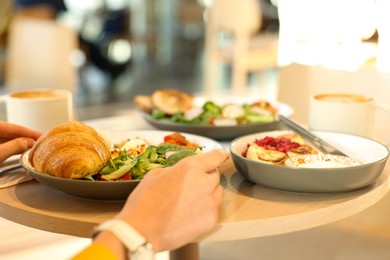 Photo of Woman having tasty breakfast in cafe, closeup