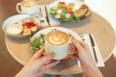 Photo of Woman having tasty breakfast in cafe, closeup