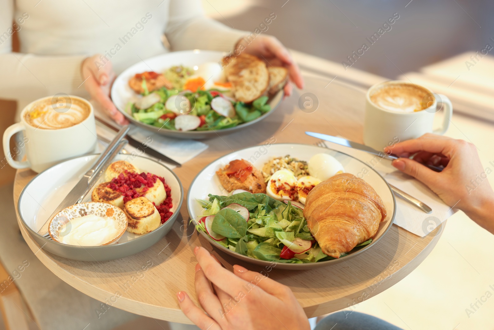 Photo of Women having tasty breakfast in cafe, closeup