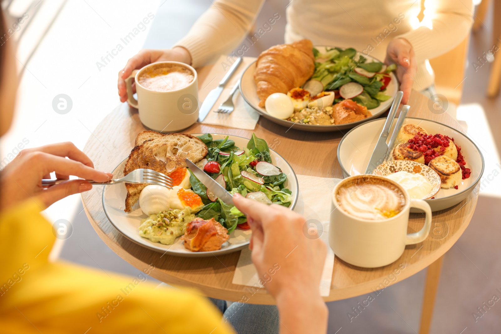 Photo of Women having tasty breakfast in cafe, closeup