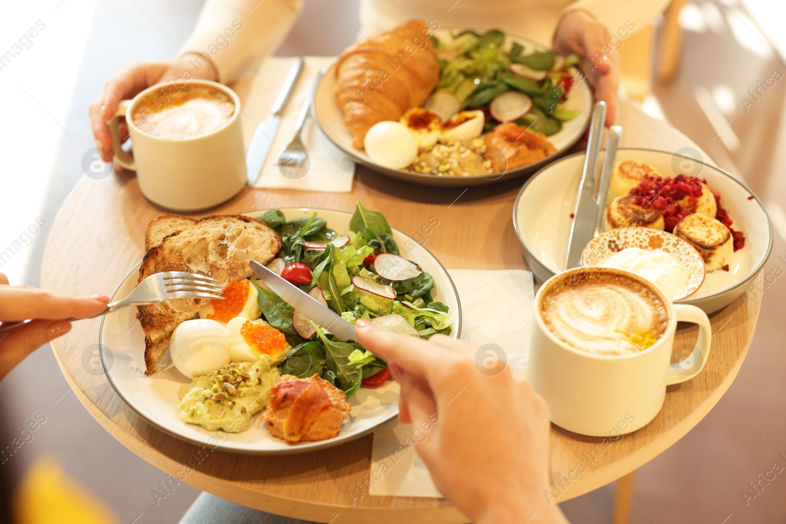 Photo of Women having tasty breakfast in cafe, closeup