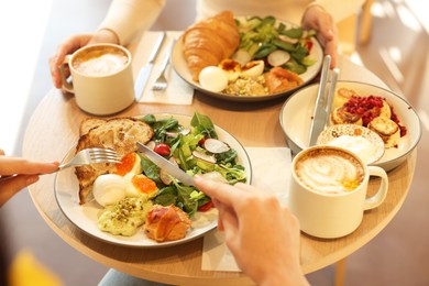 Photo of Women having tasty breakfast in cafe, closeup