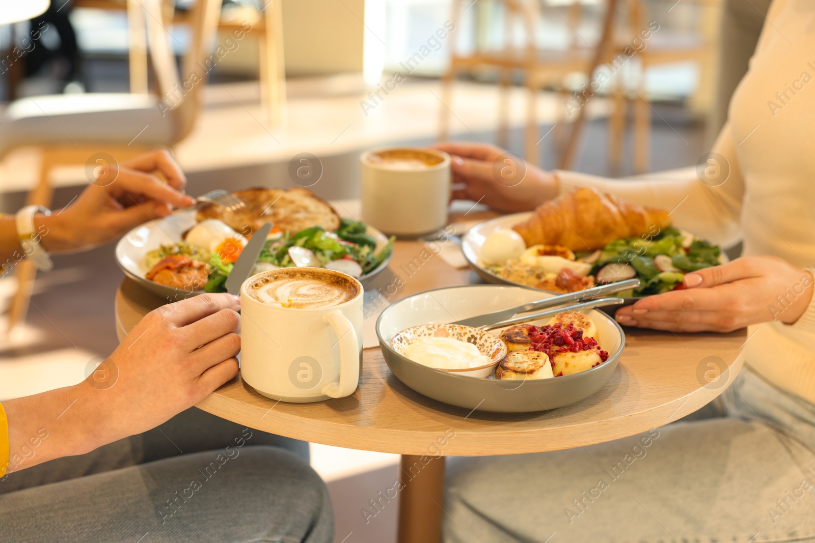 Photo of Women having tasty breakfast in cafe, closeup