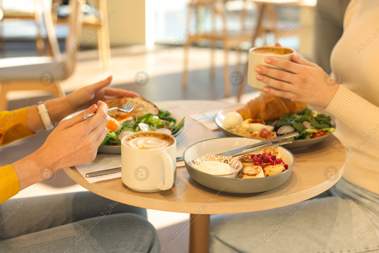 Photo of Women having tasty breakfast in cafe, closeup