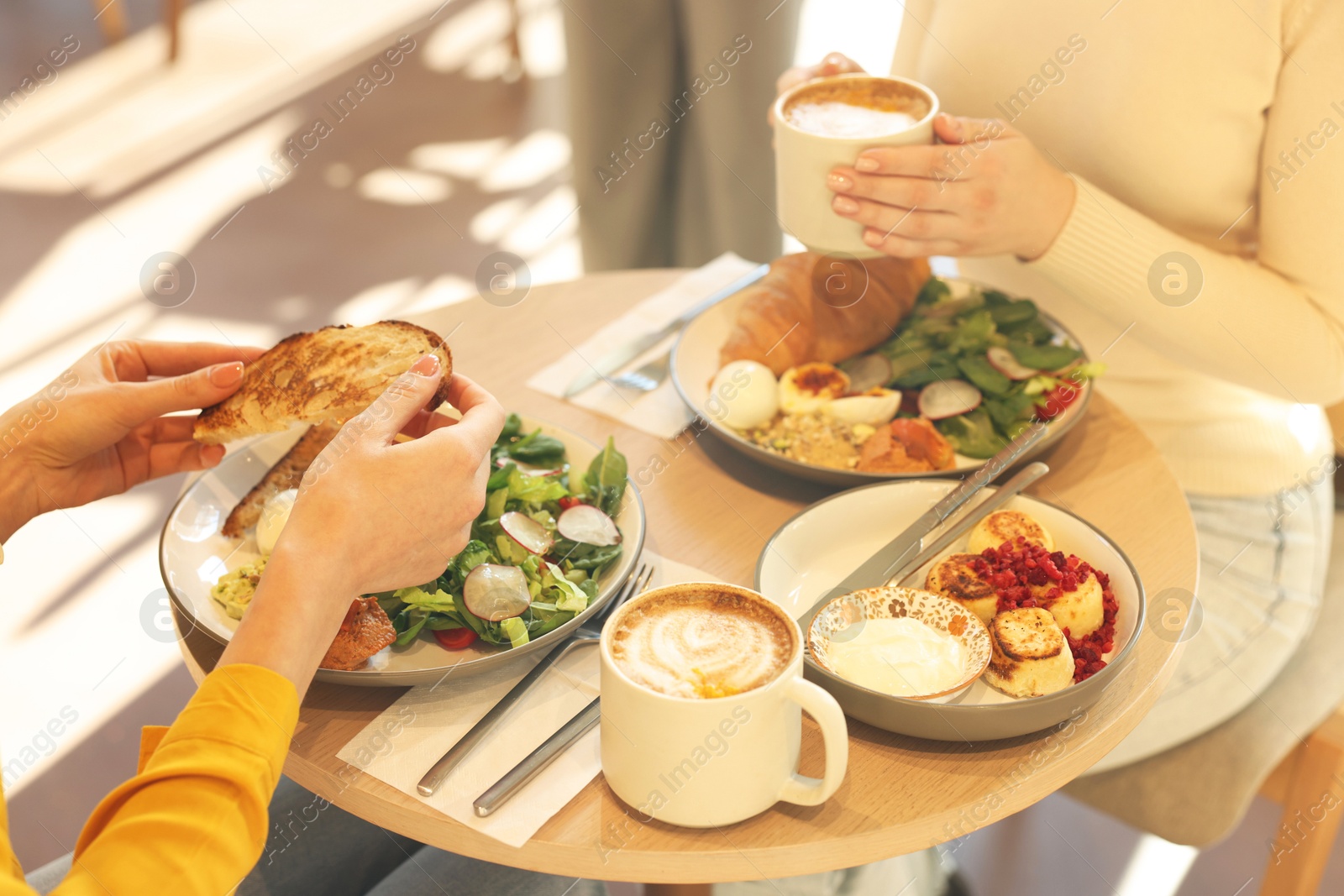 Photo of Women having tasty breakfast in cafe, closeup