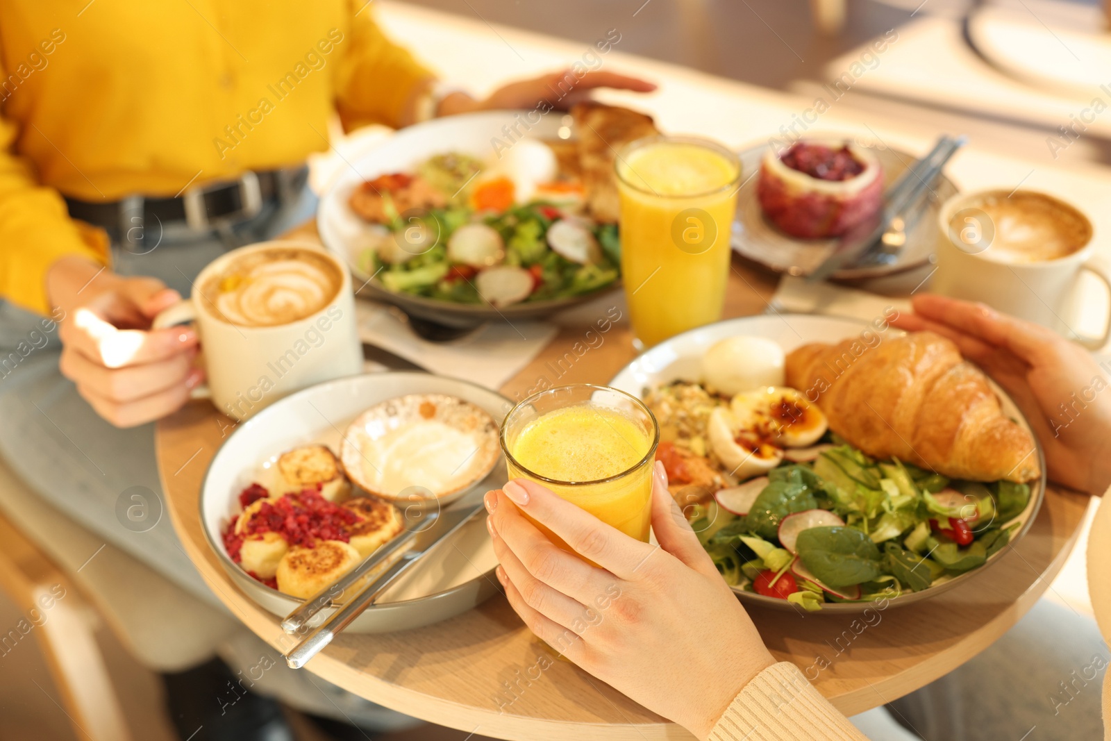 Photo of Women having tasty breakfast in cafe, closeup