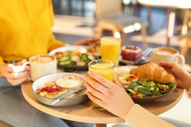 Photo of Women having tasty breakfast in cafe, closeup