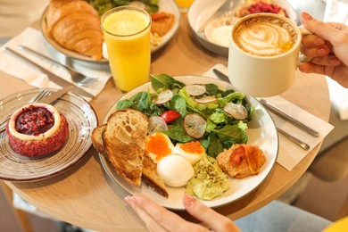 Photo of Woman having tasty breakfast in cafe, closeup