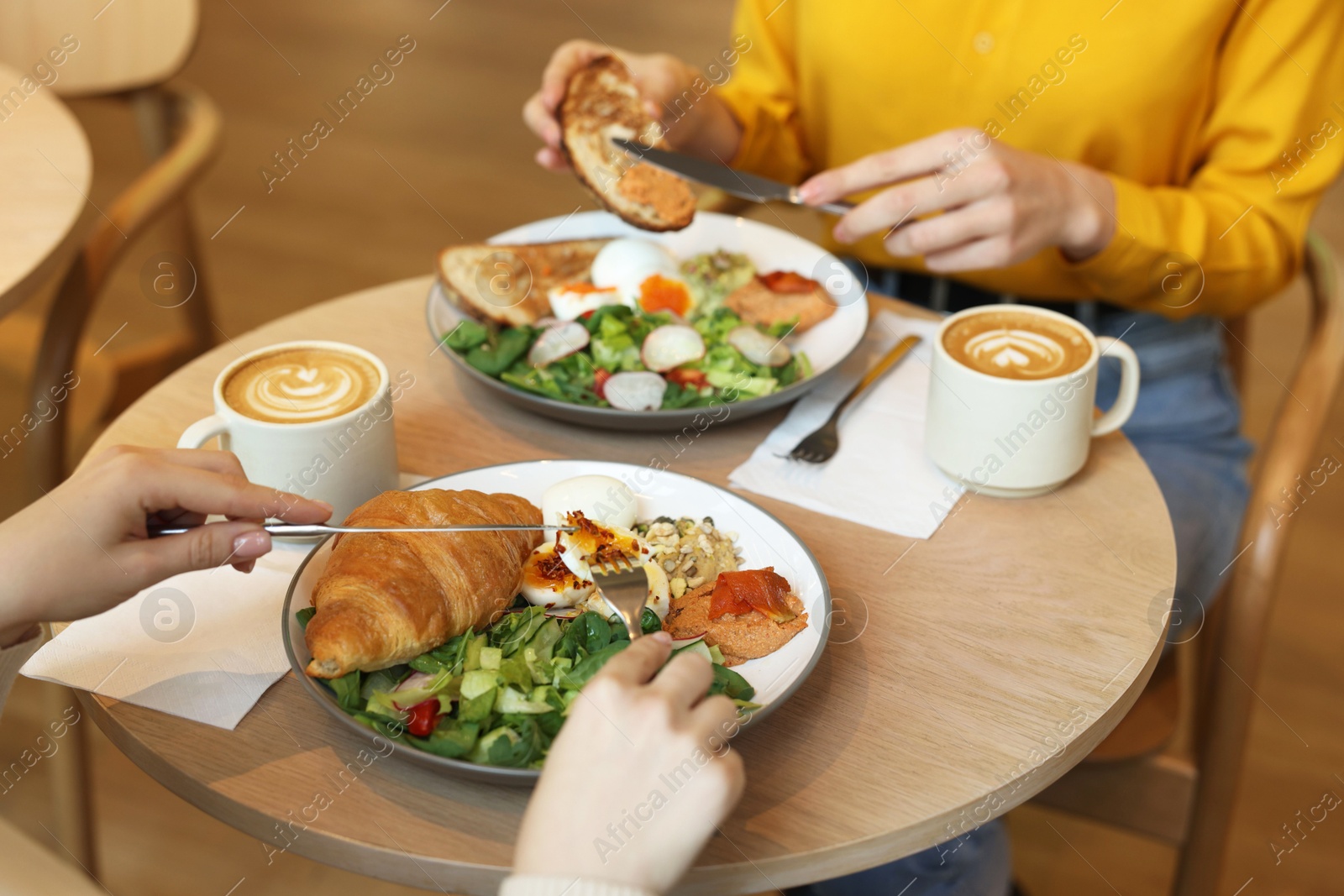 Photo of Women having tasty breakfast in cafe, closeup