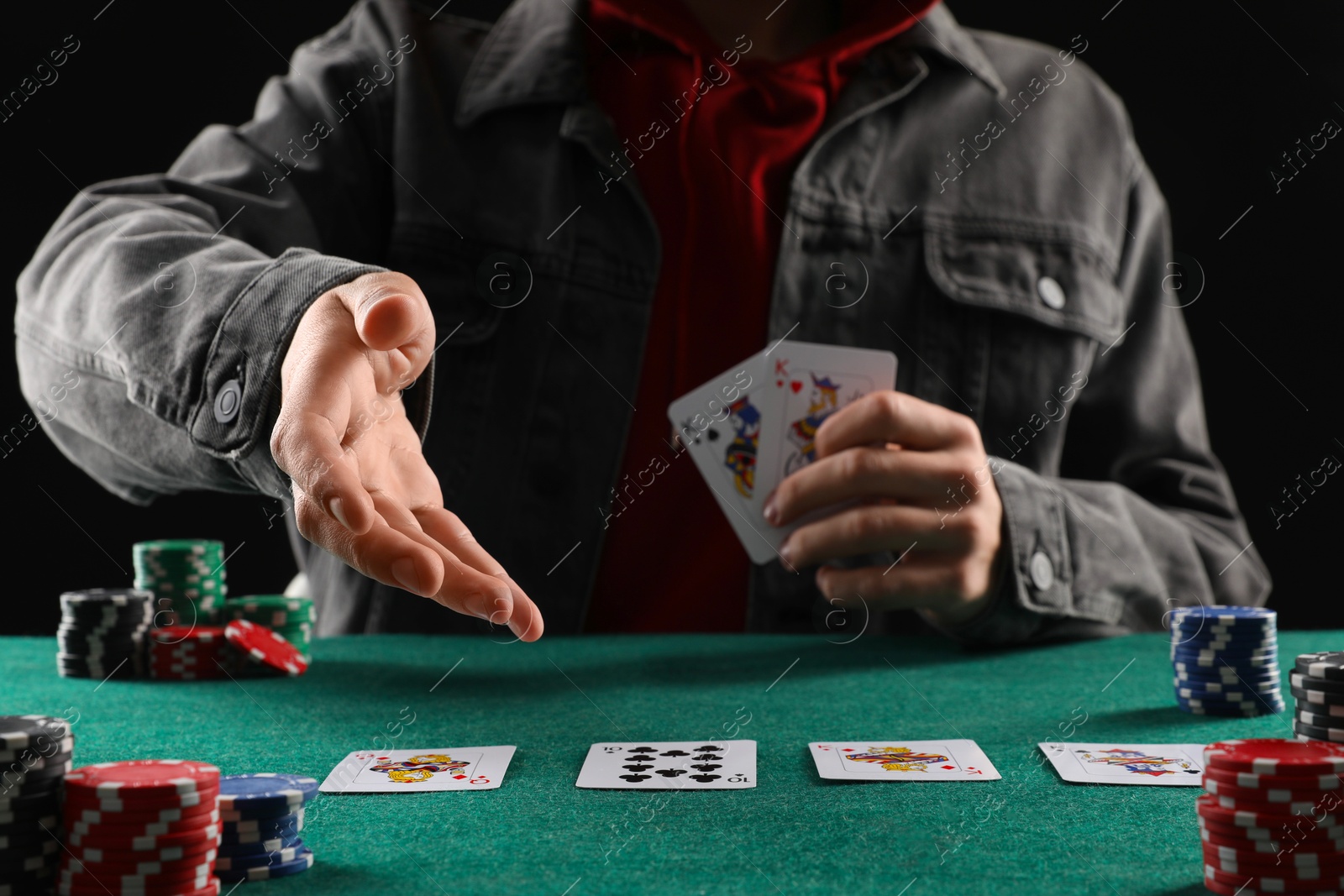 Photo of Man with cards and casino chips playing poker at gambling table, closeup