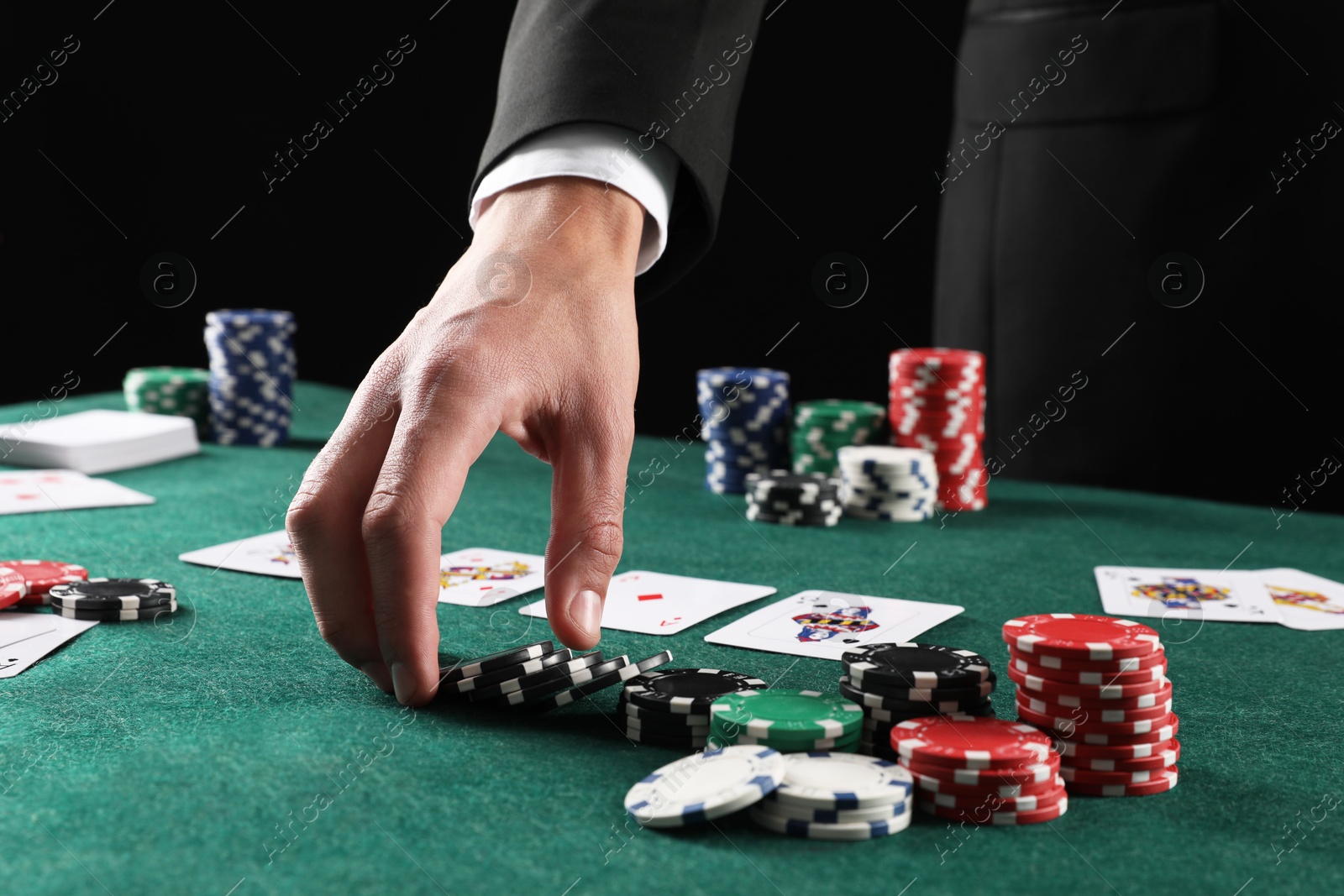 Photo of Man with cards and casino chips playing poker at gambling table, closeup