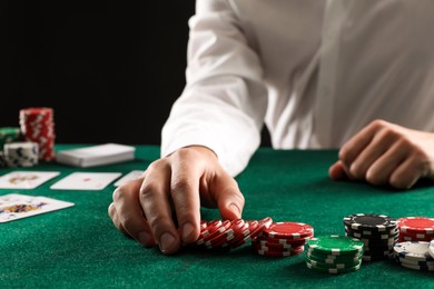 Photo of Man with cards and casino chips playing poker at gambling table, closeup