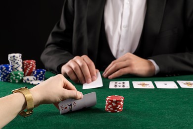 Photo of People playing poker with cards and casino chips at gambling table, closeup