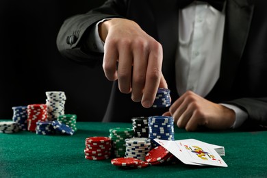 Photo of Man with cards and casino chips playing poker at gambling table, closeup