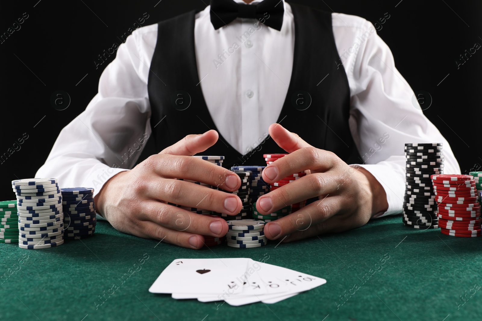 Photo of Man with cards and casino chips playing poker at gambling table, closeup