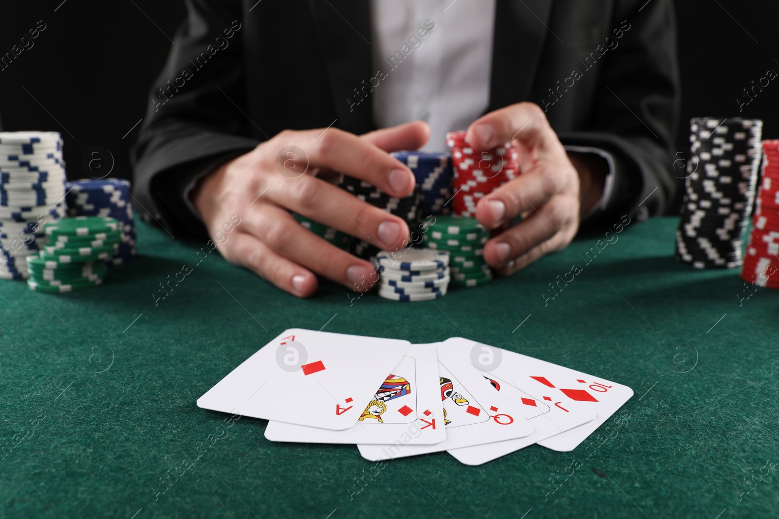 Photo of Man with cards and casino chips playing poker at gambling table, closeup