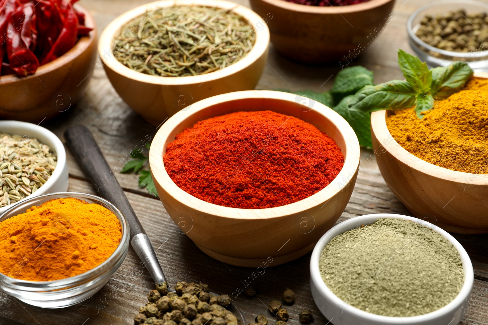 Photo of Different aromatic spices on wooden table, closeup