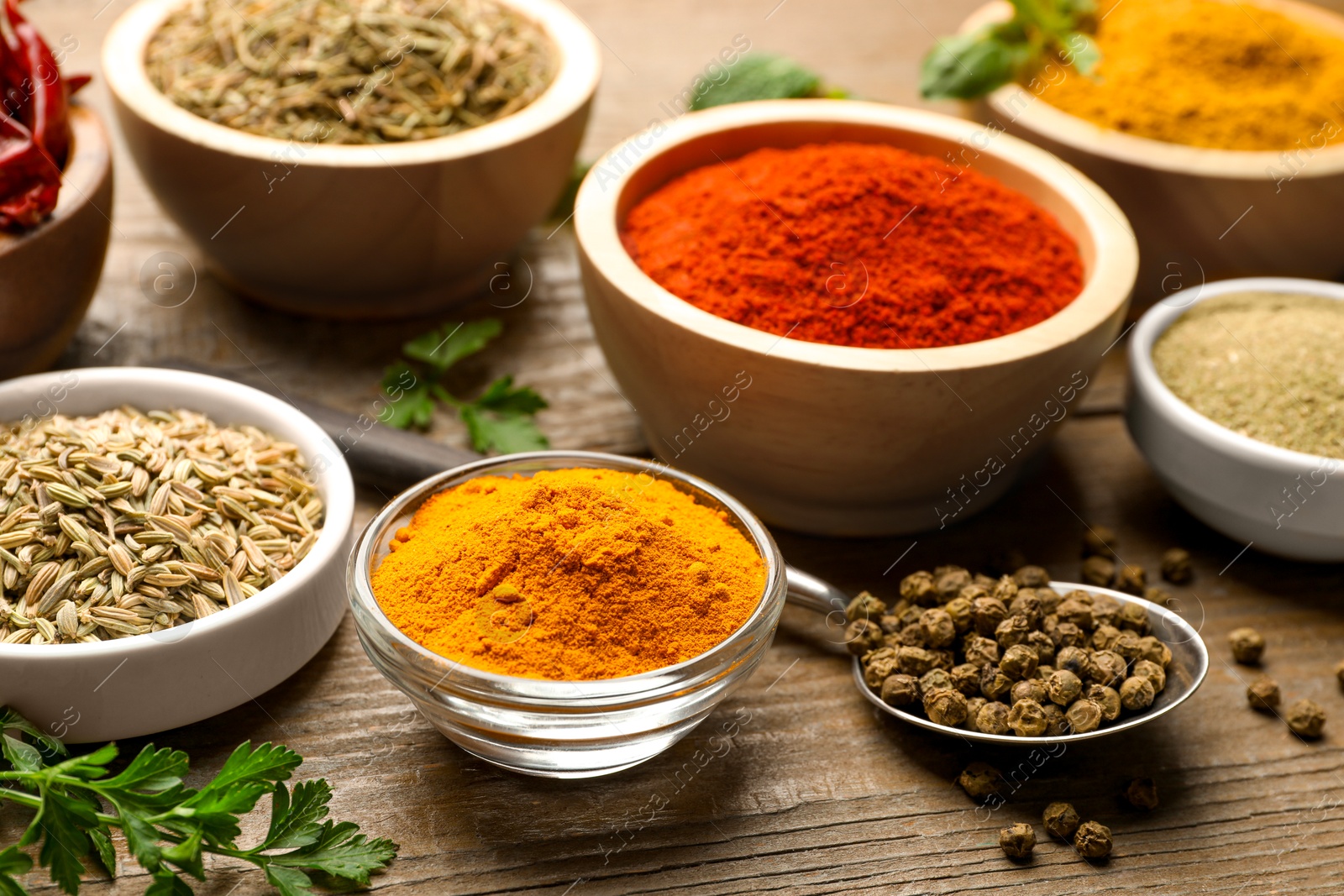 Photo of Different aromatic spices on wooden table, closeup