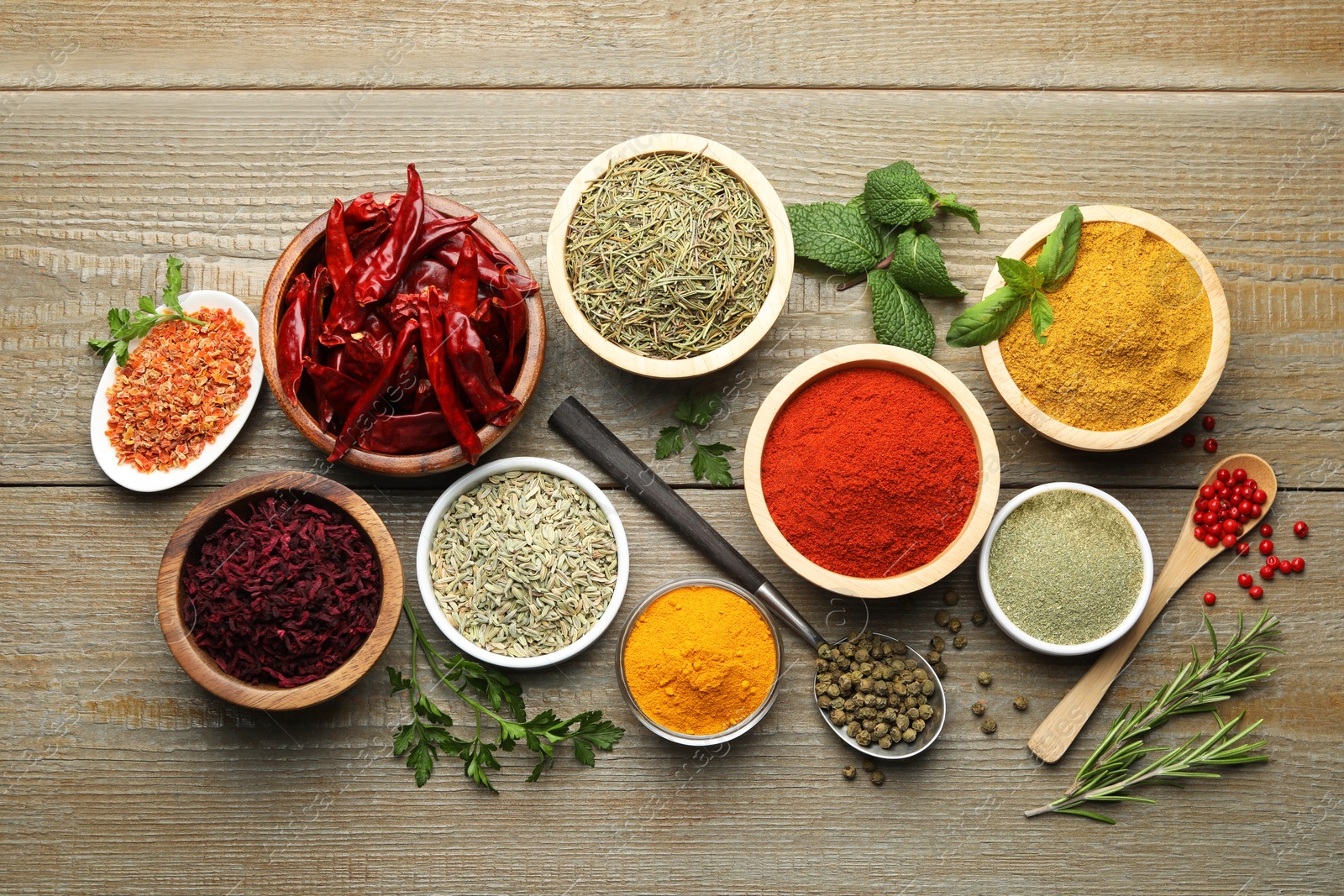 Photo of Different aromatic spices on wooden table, flat lay