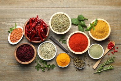 Photo of Different aromatic spices on wooden table, flat lay