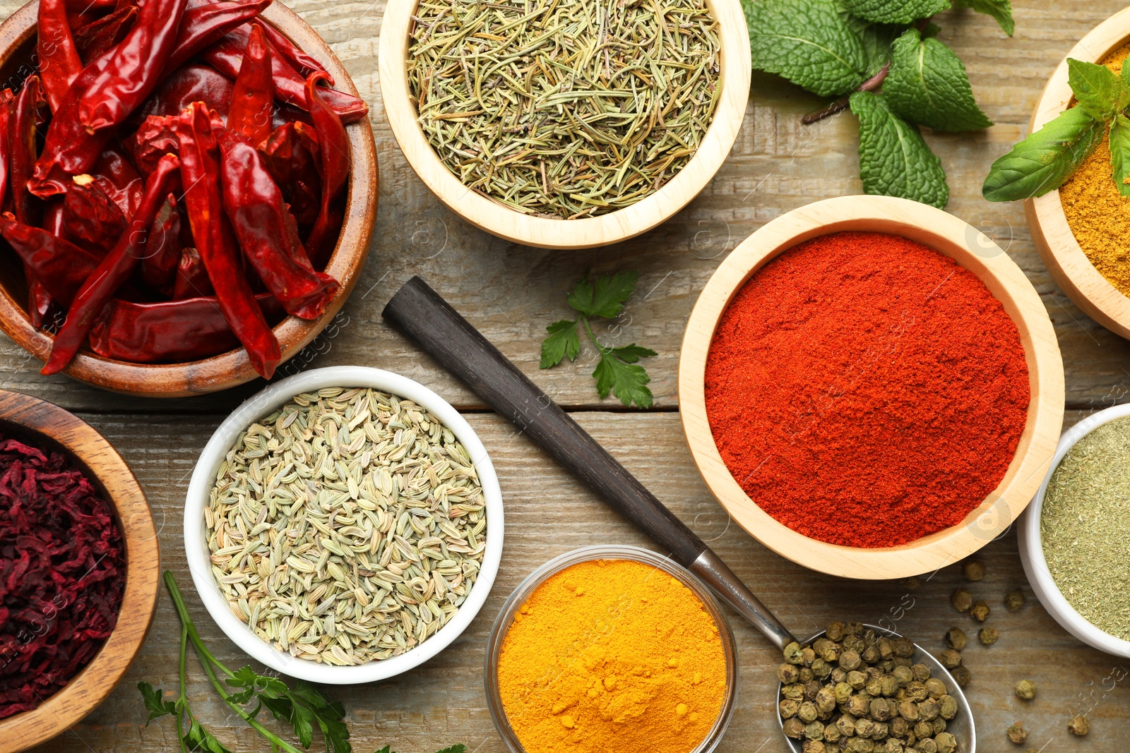 Photo of Different aromatic spices on wooden table, flat lay