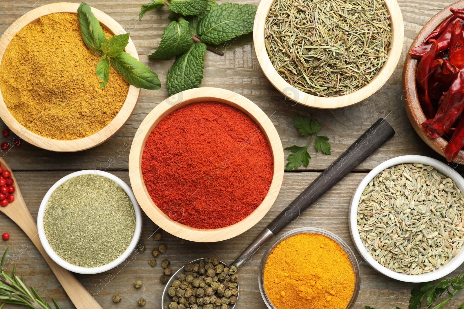 Photo of Different aromatic spices on wooden table, flat lay