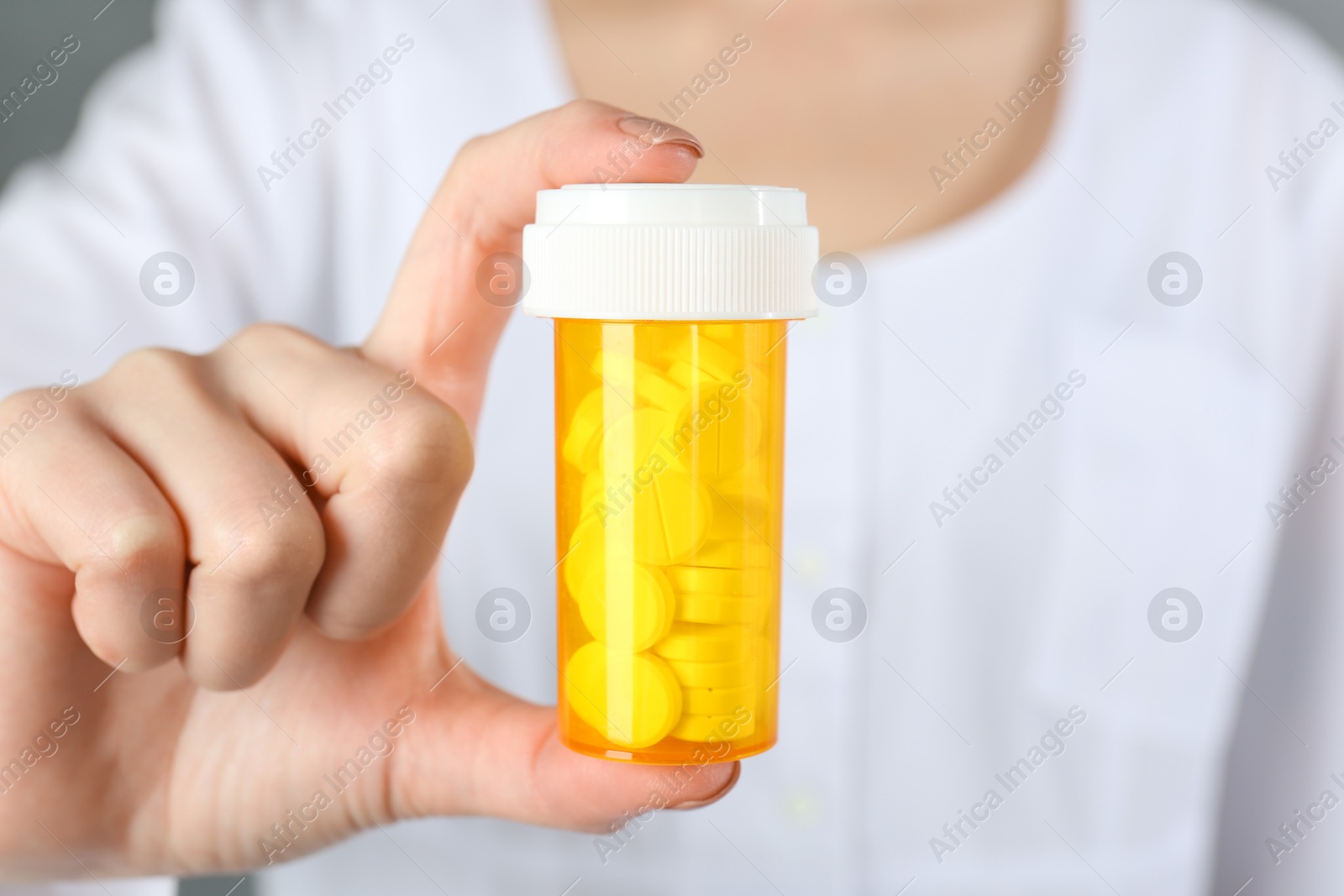 Photo of Doctor holding medical bottle of antibiotic pills, closeup