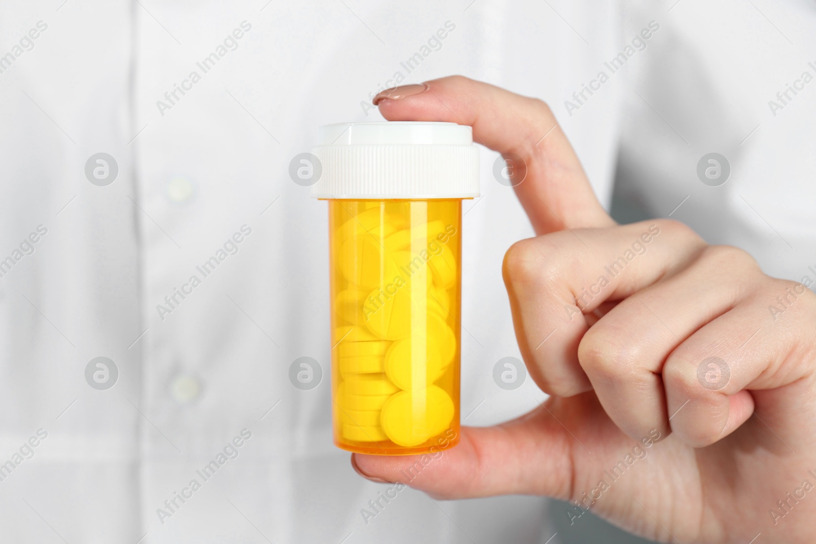 Photo of Doctor holding medical bottle of antibiotic pills, closeup