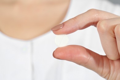 Photo of Woman holding antibiotic pill, closeup. Selective focus