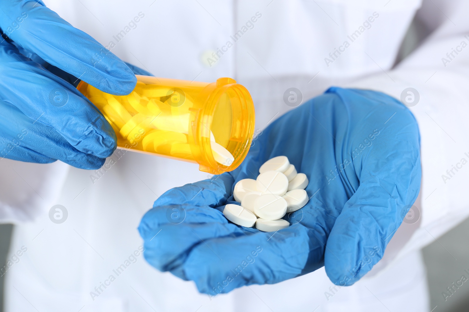 Photo of Doctor with bottle of antibiotic pills, closeup