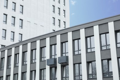 Photo of Modern buildings with many windows against blue sky