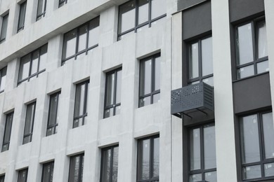 Modern building with many windows outdoors, low angle view