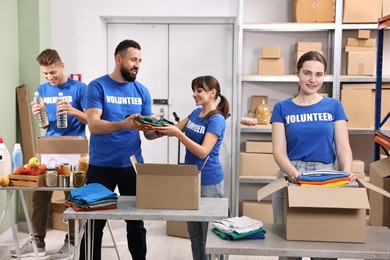 Photo of Group of volunteers packing donation goods at tables indoors