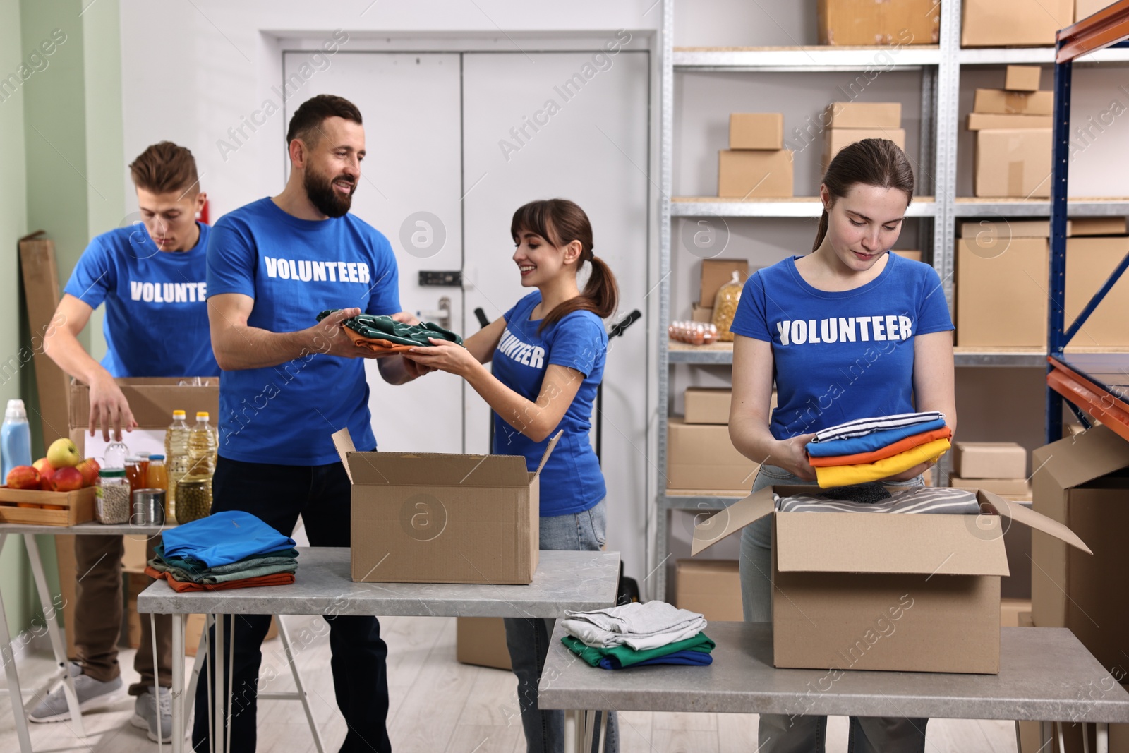 Photo of Group of volunteers packing donation goods at tables indoors